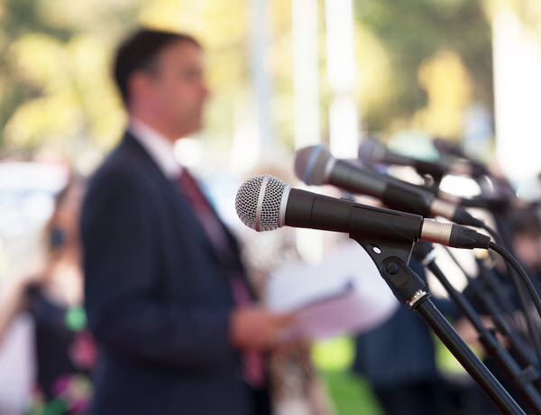 Blurred man in a conference with microphones